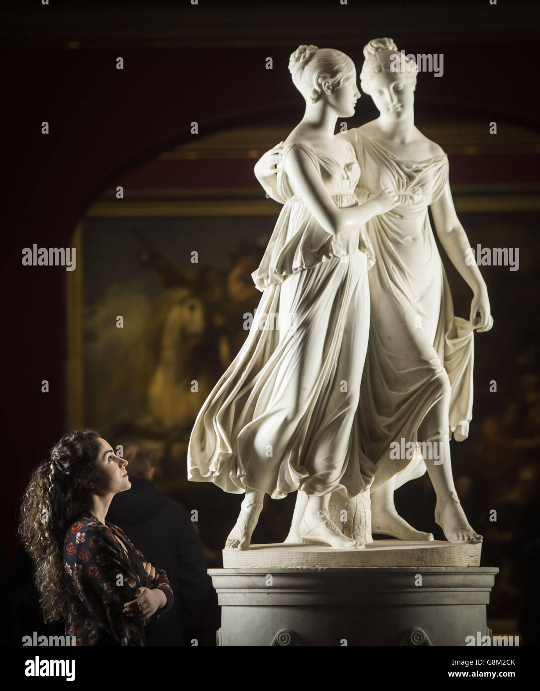 Die Mitarbeiterin der National Gallerys of Scotland Adeline Amar mit Lorenzo Bartolinis lebensgroßer Marmorportrait-Gruppe The Campbell Sisters Dancing a Waltz während einer Fotoausstellung in der Scottish National Gallery in Edinburgh. Stockfoto