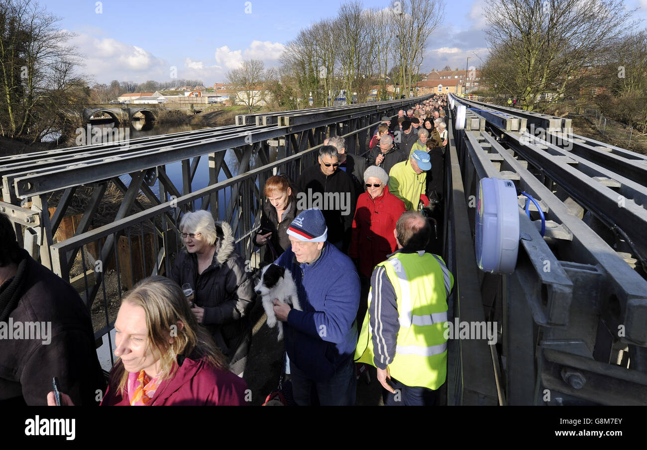 Die Bewohner von Tadcaster überqueren zum ersten Mal eine provisorische Fußgängerbrücke, die nach dem Einsturz der Hauptbrücke nach schweren Überschwemmungen errichtet wurde, um die Stadt wieder zu vereinen. Stockfoto