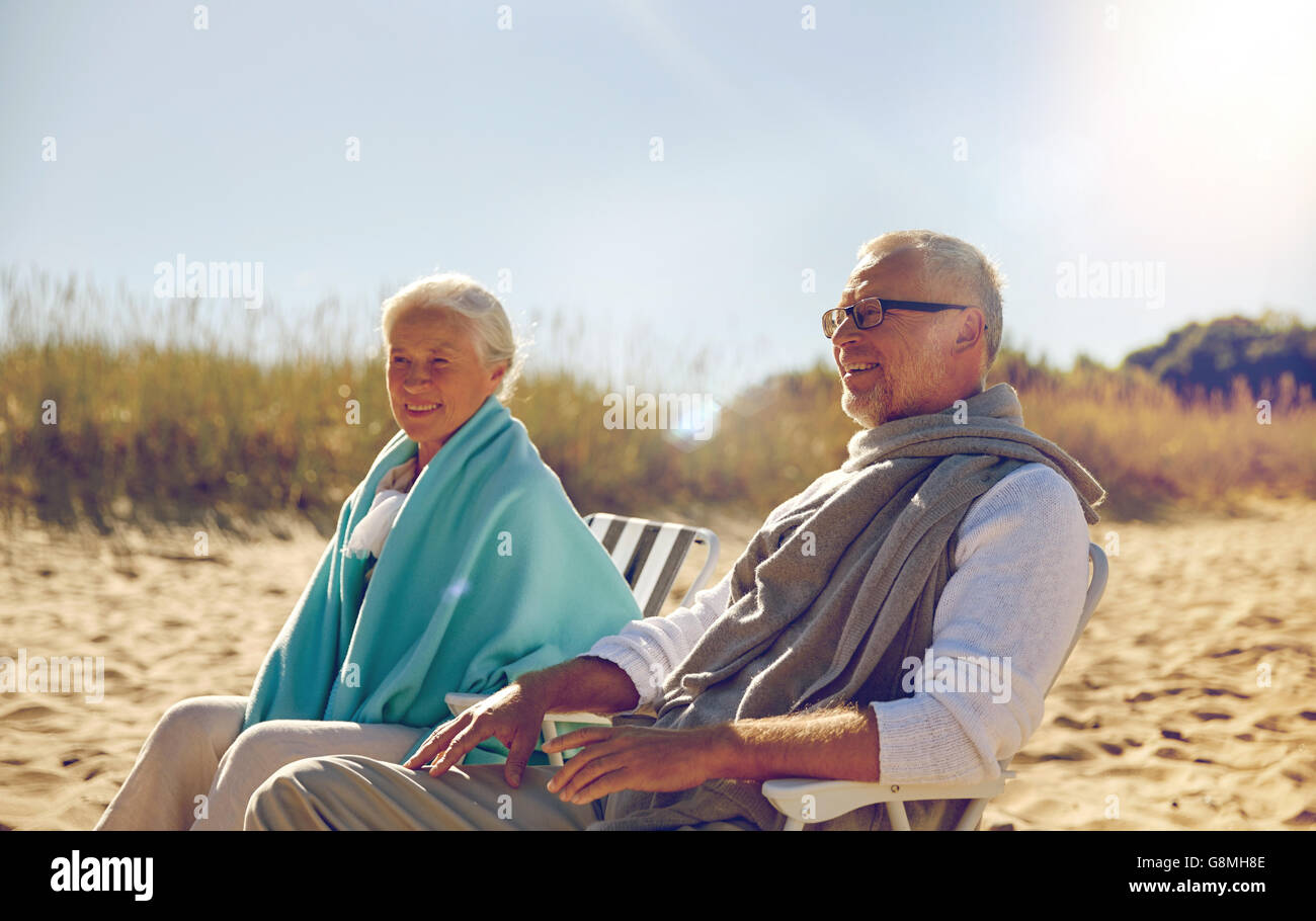 gerne älteres Paar in den Stühlen am Sommerstrand Stockfoto