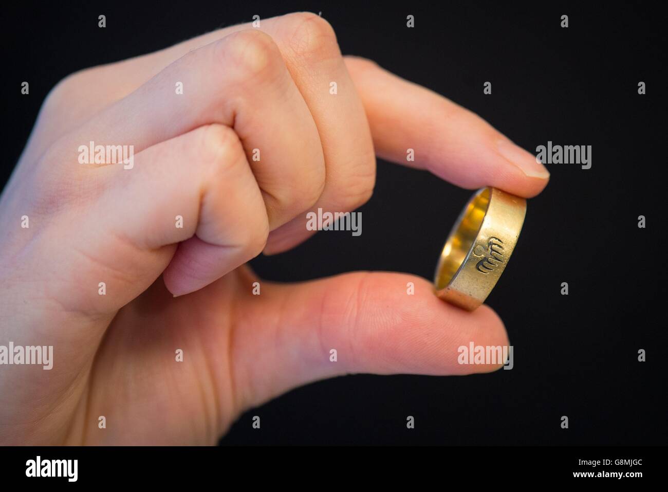 Ein Christies-Mitarbeiter hält einen 9 Karat goldenen Spectre-Ring, der von  Christoph Waltz im James Bond-Film 'Spectre' im Wert von  &ACIRC;&pound;4,000 - &ACIRC;&pound;6,000 bei Christie's in London getragen  wird, im Rahmen des am