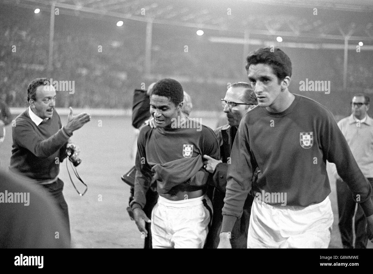 Fußball - Weltmeisterschaft England 1966 - Halbfinale - Portugal gegen England - Wembley-Stadion. Die Portugiesen Eusebio (l) und Jose Torres (r) stachen nach der Niederlage ihres Teams im Jahr 2-1 dejectedly vom Spielfeld Stockfoto