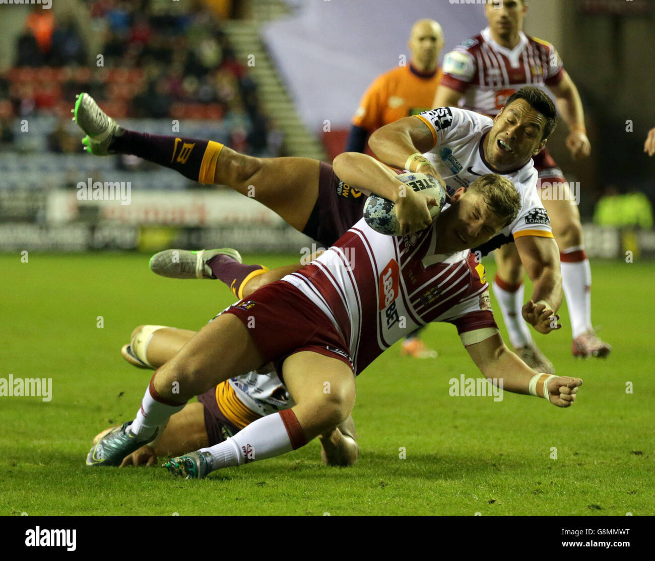 George Williams von Wigan Warriors wird von Alex Glenn von Brisbane Broncos während des Spiels der World Club Series im DW Stadium in Wigan angegangen. Stockfoto