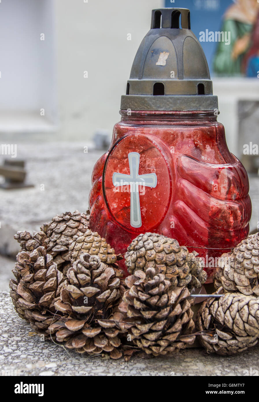 Rote Kerze und Pinien Zapfen auf einem Marmor Grab in Brasov, Rumänien Stockfoto