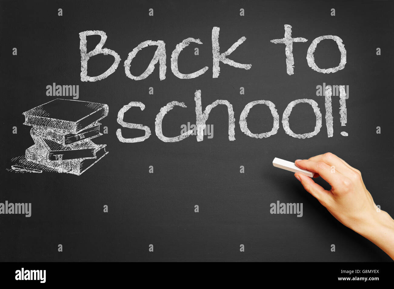 Hand schreibt "Back to School!" auf Tafel Stockfoto