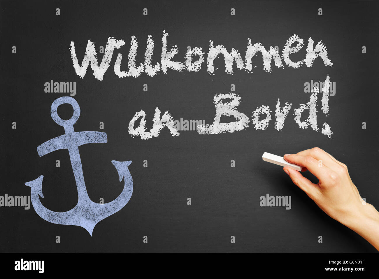 Hand, schreibt in Deutsch "Willkommen an Bord!" (Willkommen Sie an Bord!) auf Tafel Stockfoto