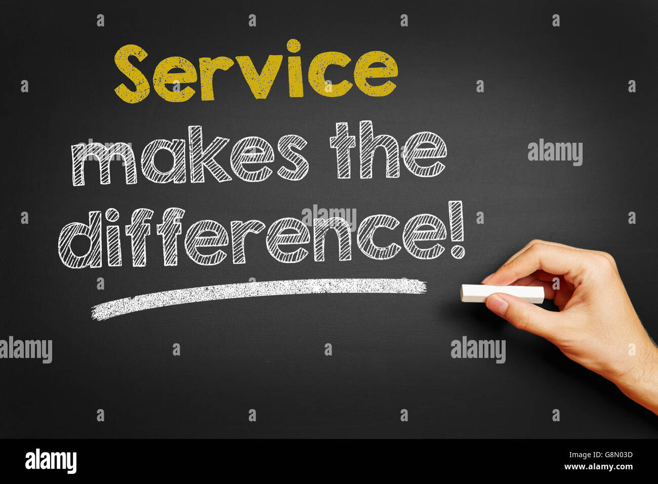Hand schreibt auf Tafel "Service macht den Unterschied!" Stockfoto