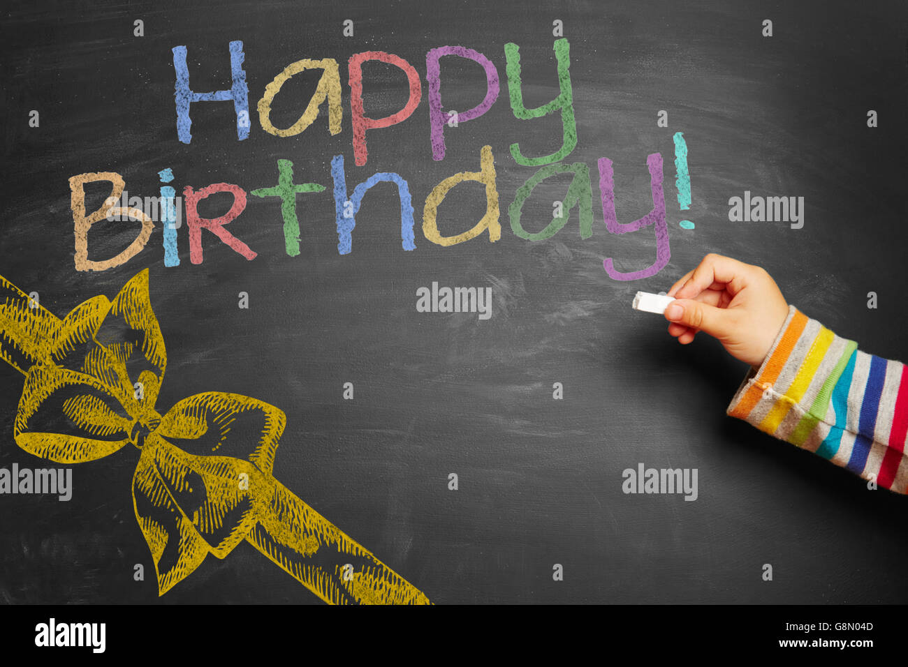 Kind an der Hand einen bunten "Happy Birthday!" an Tafel schreiben Stockfoto