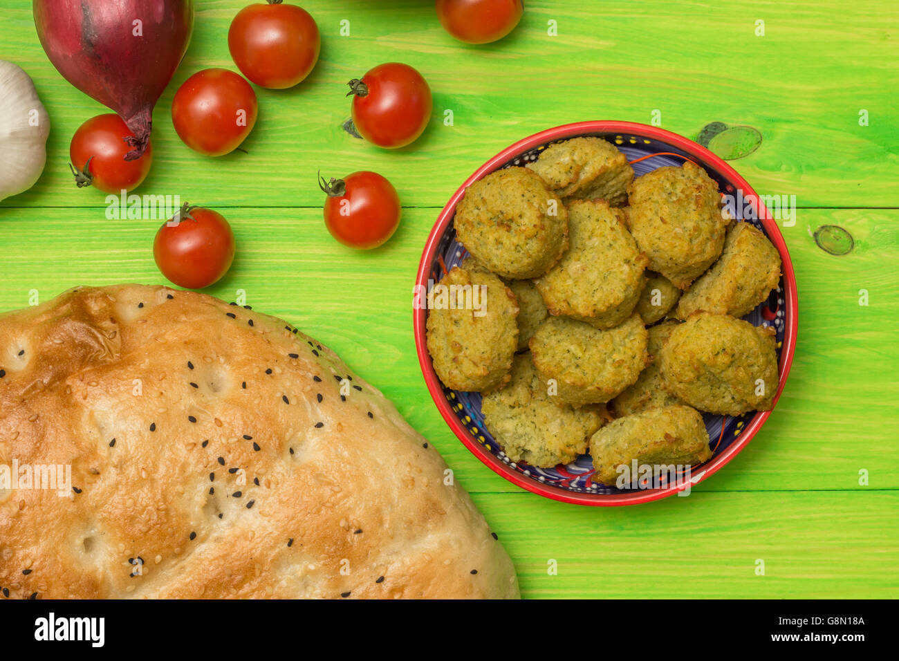 Falafel, türkische Pidebrot und Gemüse am grünen Tisch Stockfoto
