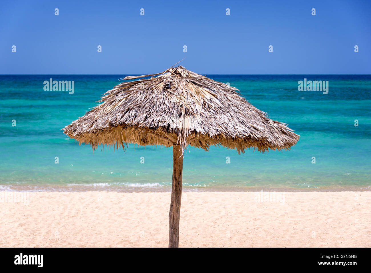 Strohschirm am tropischen Strand Stockfoto