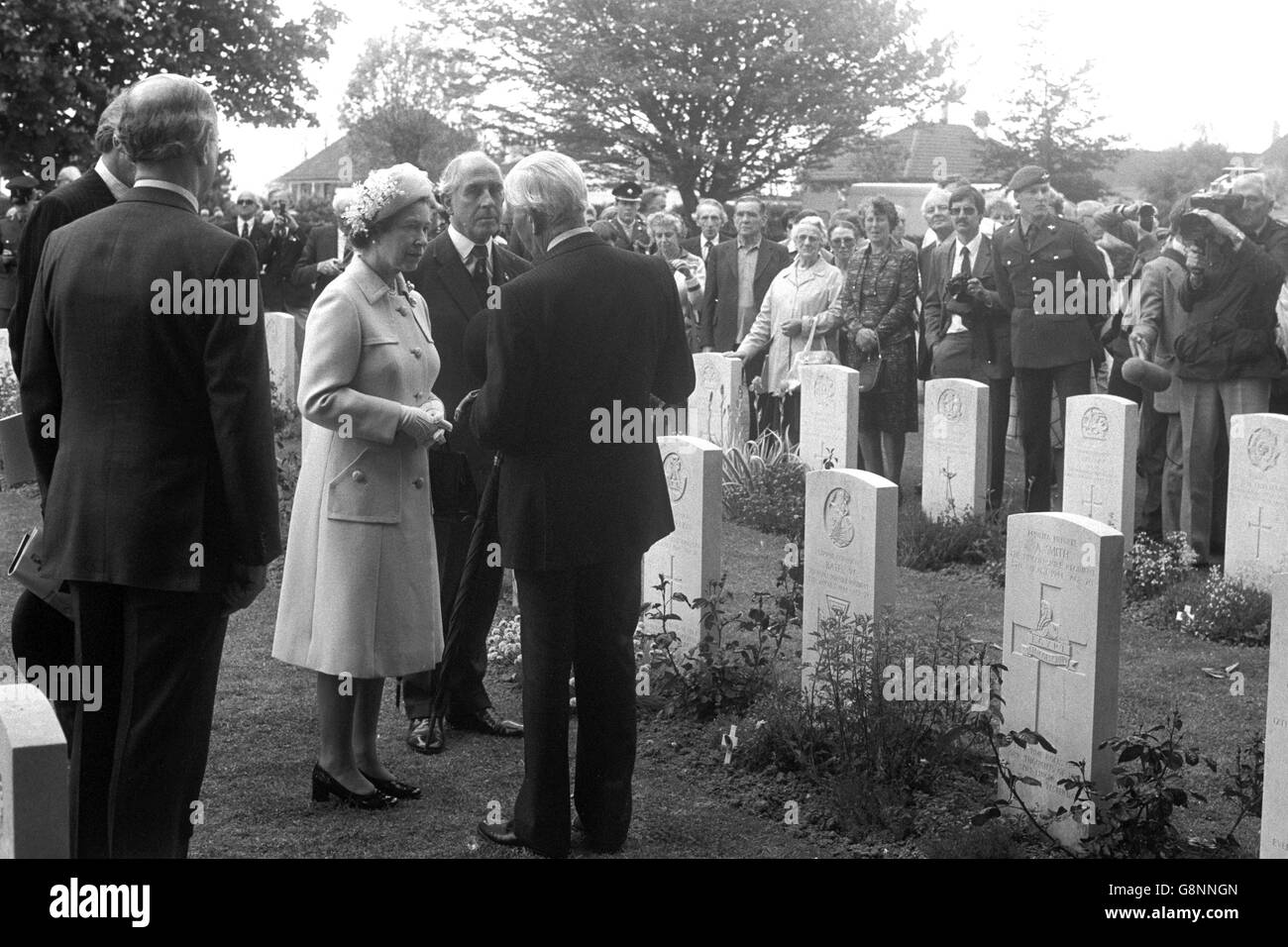 Königin Elizabeth II. Steht am Grabstein von Corporal S. Bates VC, Royal Norfolk Regiment, auf dem britischen Friedhof Bayeux, Frankreich, und plaudert mit Überlebenden der D-Day Landungen während der D-Day Jubiläumszeremonie. Stockfoto