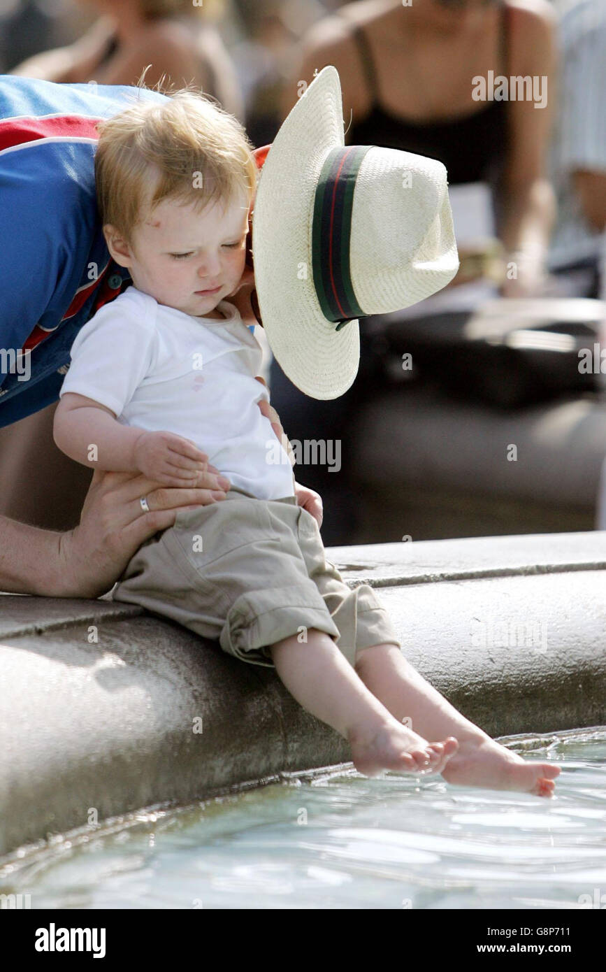 Einem Kind wird am Sonntag, dem 4. September 2005, beim Baden in den Springbrunnen am Trafalgar Square, London, geholfen, da die Hauptstadt die Septembersonne genießt. DRÜCKEN SIE VERBANDSFOTO. Bildnachweis sollte lauten: Jane Mingay/PA Stockfoto