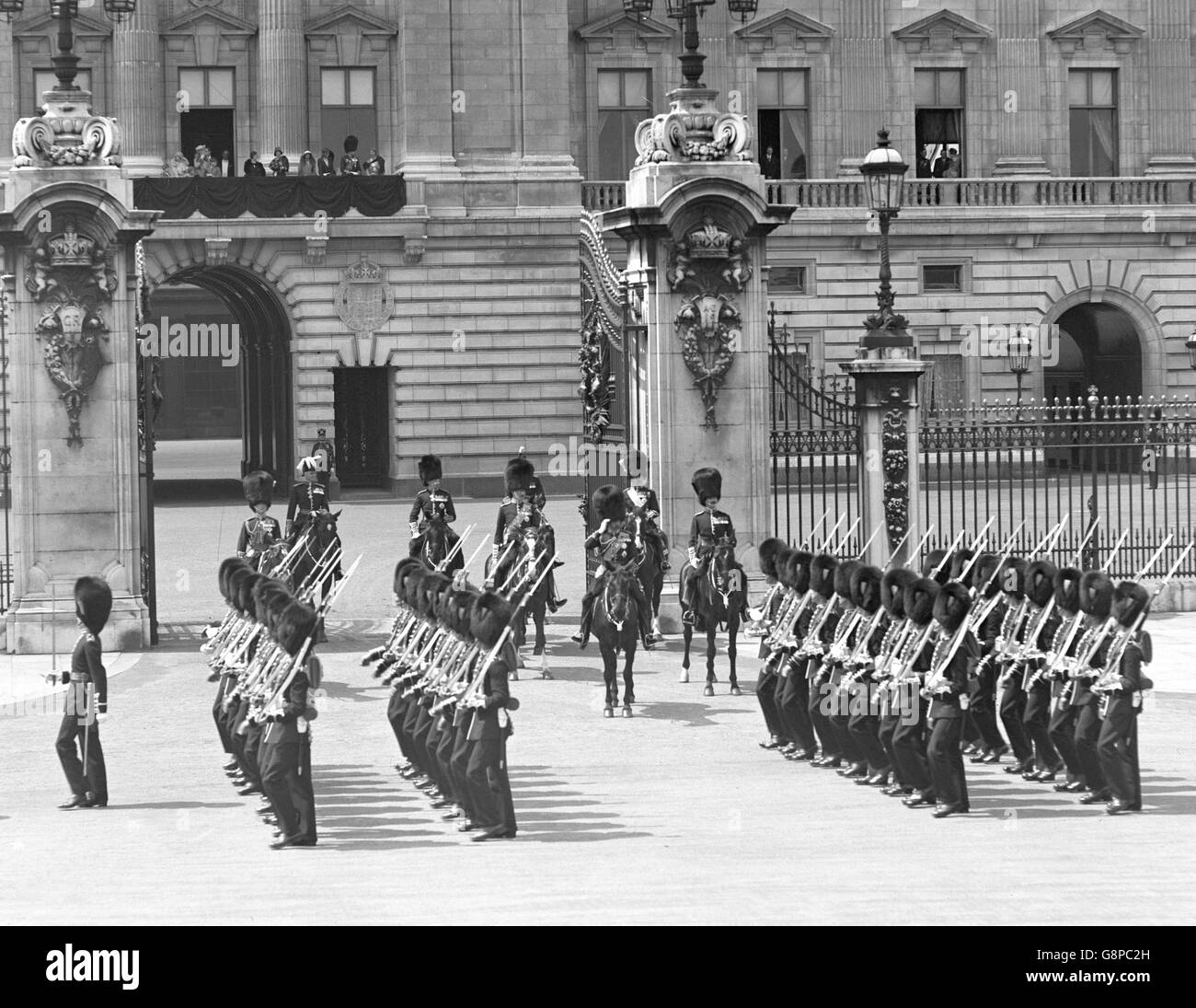 König George V und der Prinz von Wales beobachten die Truppen, die nach der Trooping the Color Zeremonie am Buckingham Palast vorbeimarschieren. Stockfoto