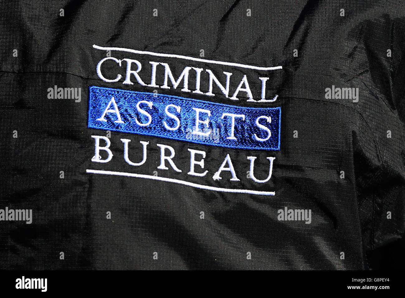 Das Logo auf einer Jacke eines Mitglieds des Criminal Assets Bureau, das Hausdurchsuchungen und Geschäfte in Dublin durchführt, die auf die Aktivitäten einer in der Innenstadt ansässigen Kriminalgruppe abzielen, die mit David Byrne in Verbindung steht, der im Regency Hotel ermordet wurde. Stockfoto