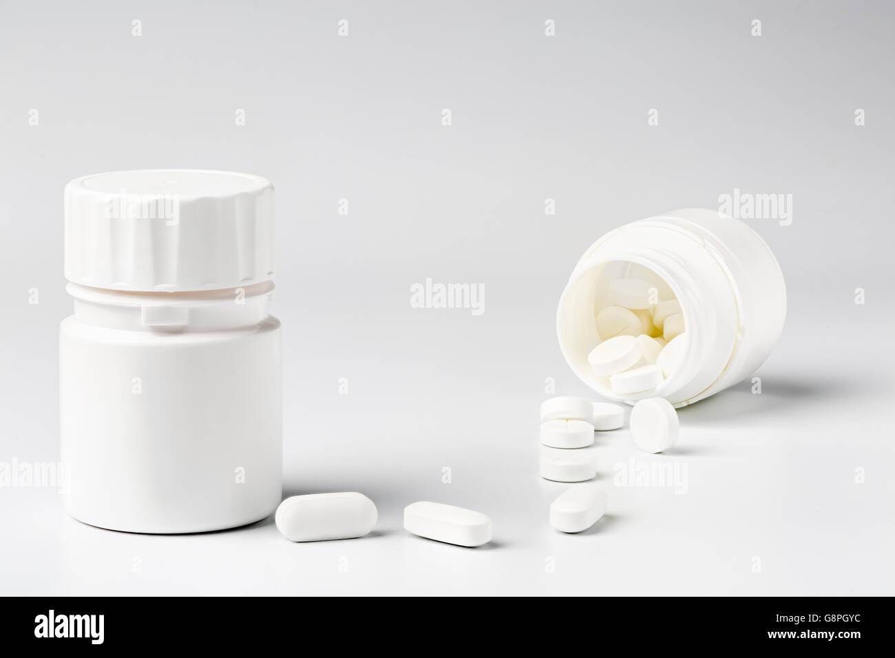 Weiße Kunststoff Tablettenfläschchen und Pillen auf weißem Hintergrund Stockfoto