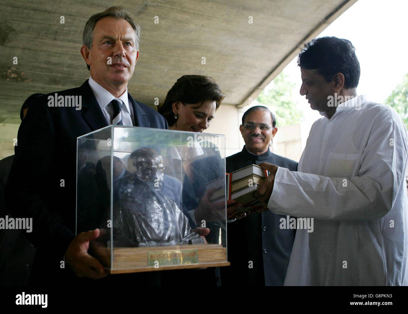 Der britische Premierminister Tony Blair (links) wird nach der Kranzniederlegung am Gandhi-Denkmal in Neu-Delhi am Mittwoch, den 7. September 2005, in Begleitung seiner Frau Cherie (zweite links) mit einer Bronzestatue überreicht. Blair wird am heutigen EU-Indien-Gipfel teilnehmen, wo er argumentieren wird, dass der Westen Indiens Aufstieg als Wirtschaftsmacht begrüßen sollte, anstatt ihn als Bedrohung für den Diebstahl von Arbeitsplätzen zu fürchten. Siehe PA Geschichte INDIEN Blair. DRÜCKEN Sie VERBANDSFOTO. Bildnachweis sollte lauten: John D McHugh/PA/WPA Rota AFP. Stockfoto