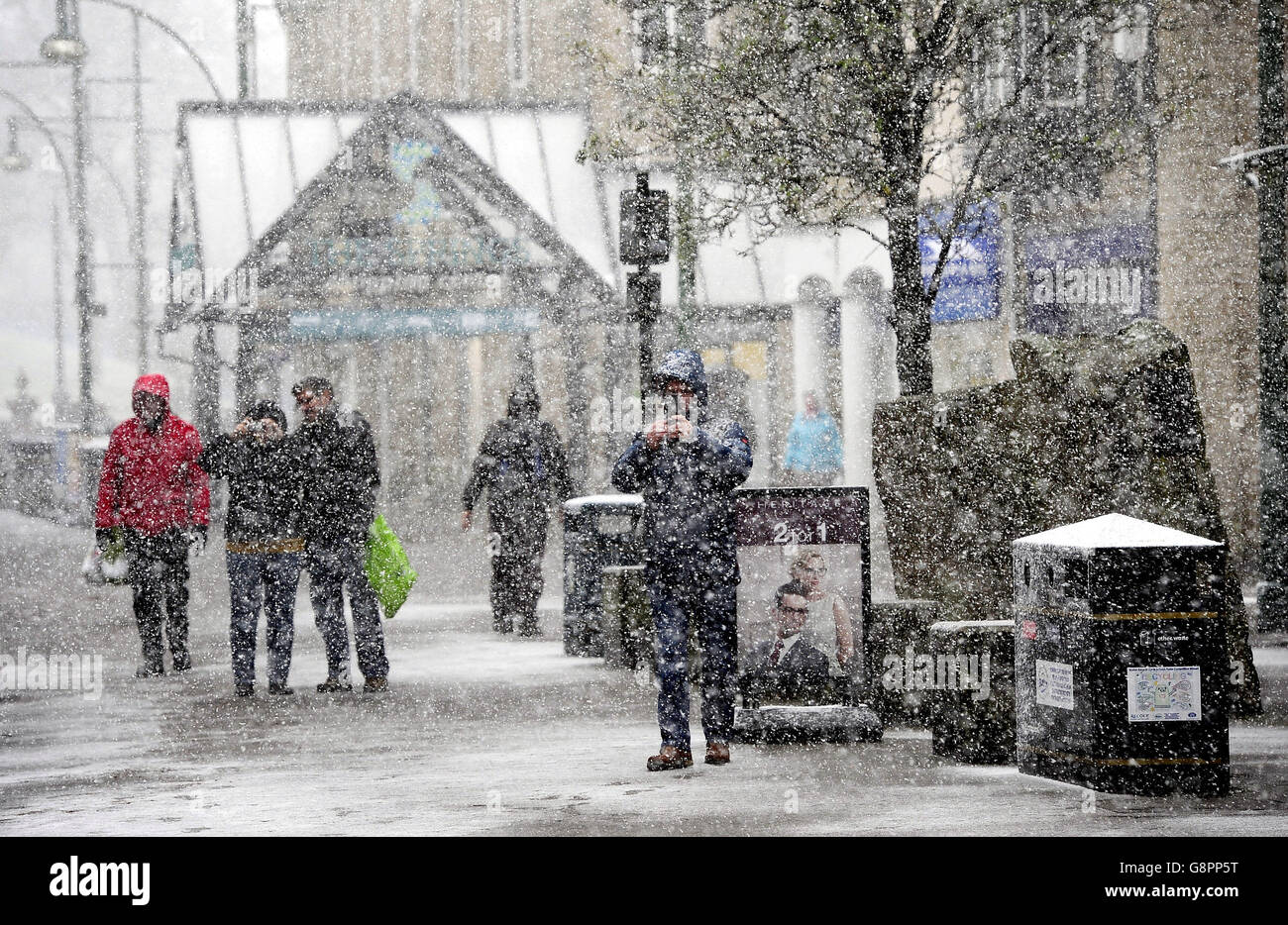 Die Menschen machen sich auf den Weg durch das Stadtzentrum von Buxton, Derbyshire, da Prognostiker sagten, dass Sturm Jake Eis, Schnee und Winde mit einer Geschwindigkeit von 70 km/h bringen könnte. Stockfoto