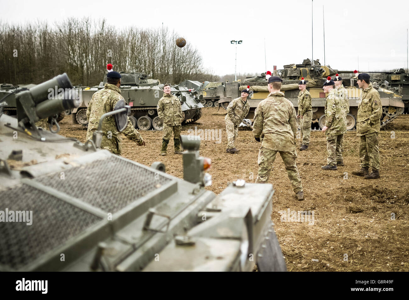 Soldaten des 1. Bataillons First Fusiliers treten einen Fußball herum, während sie sich nach der Zeit in ihren Scimitar-Tanks entspannen, während die 3. (UK) Division an der Übung TRACTABLE 2016 auf Salisbury Plain, Wiltshire, Das soll die Fähigkeit der LATF (Lead Armoured Task Force) der Division testen, sich von Kasernen über einen zentralen Einsatzbereich an Luft- und Seepunkte zu verteilen. Stockfoto