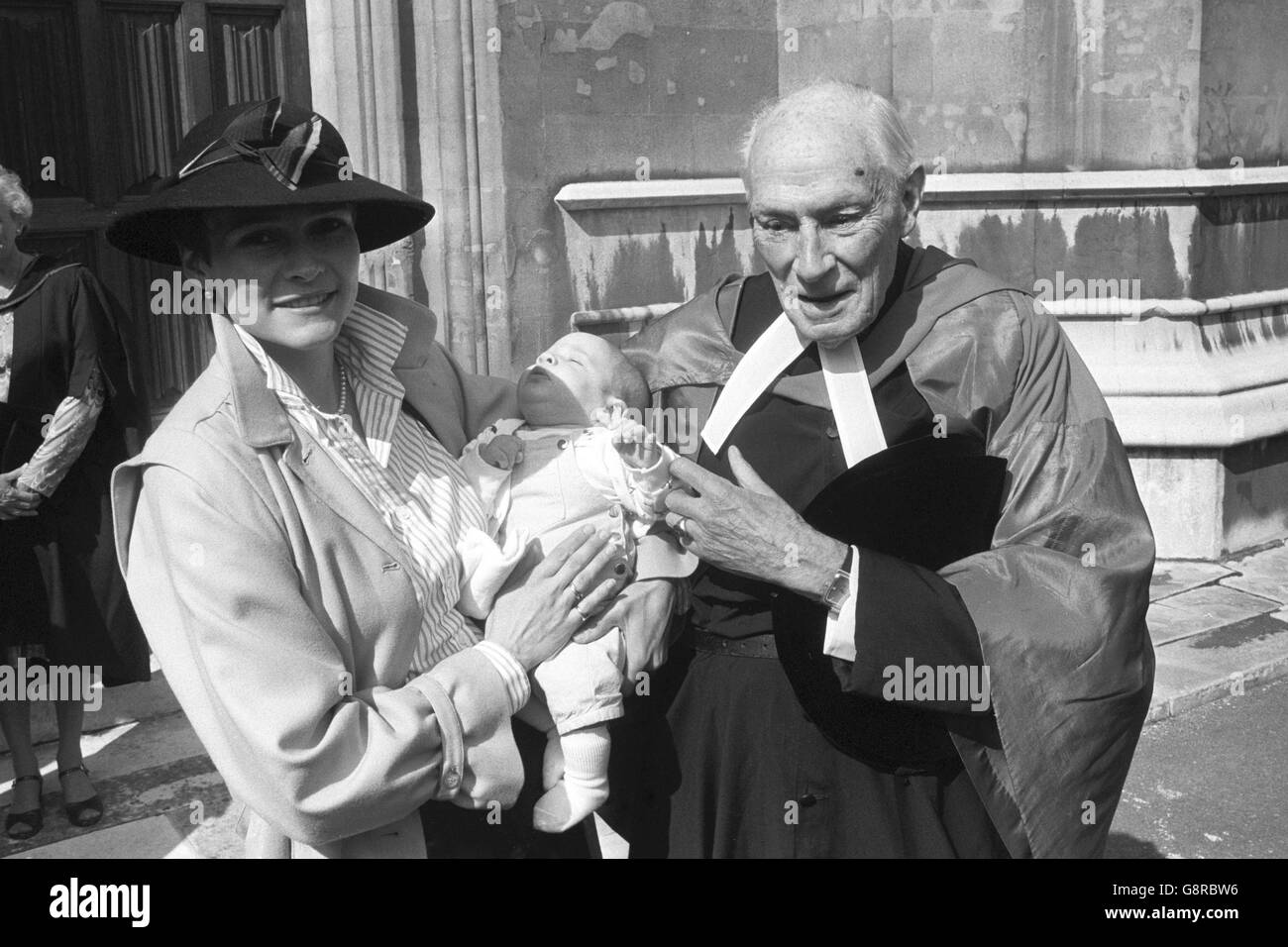 Kanzler Garth Moore, der pensionierte Kanzler der Diözesen Durham, Gloucester und Southwark und ehemaliger Vorsitzender der Rechtsberatungskommission, mit seinem Cousin Penny Rawlinson und ihrem 10 Wochen alten Sohn Anthony. Sie befanden sich vor der Lambeth Palace Chapel, wo Moore vom Erzbischof von Canterbury, Dr. Robert Runcie, mit dem Lambeth-Doktortitel für Zivilrecht ausgezeichnet wurde. Der Abschluss würdigt seine Dienste im Bereich des kanonischen und kirchlichen Rechts für die Kirche. Stockfoto