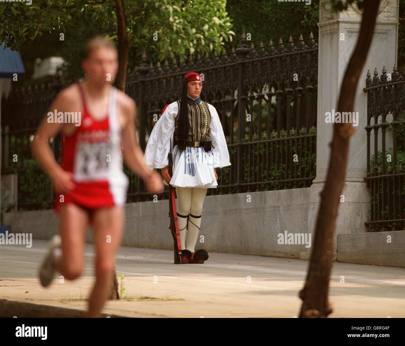 Leichtathletik - Sechste IAAF-Weltmeisterschaften - Athen 1997 - Marathon der Männer. Ein griechischer Soldat (rechts) beobachtet einen Läufer vorbei Stockfoto