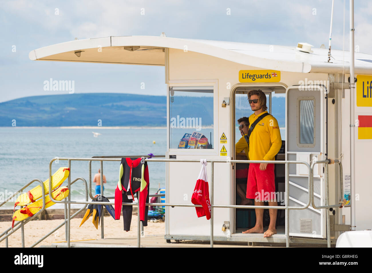 RNLI-Rettungsschwimmer im Juni in der Rettungsschwimmer-Kiosk-Hütte am Alum Chine Beach, Bournemouth, Dorset, Großbritannien Stockfoto