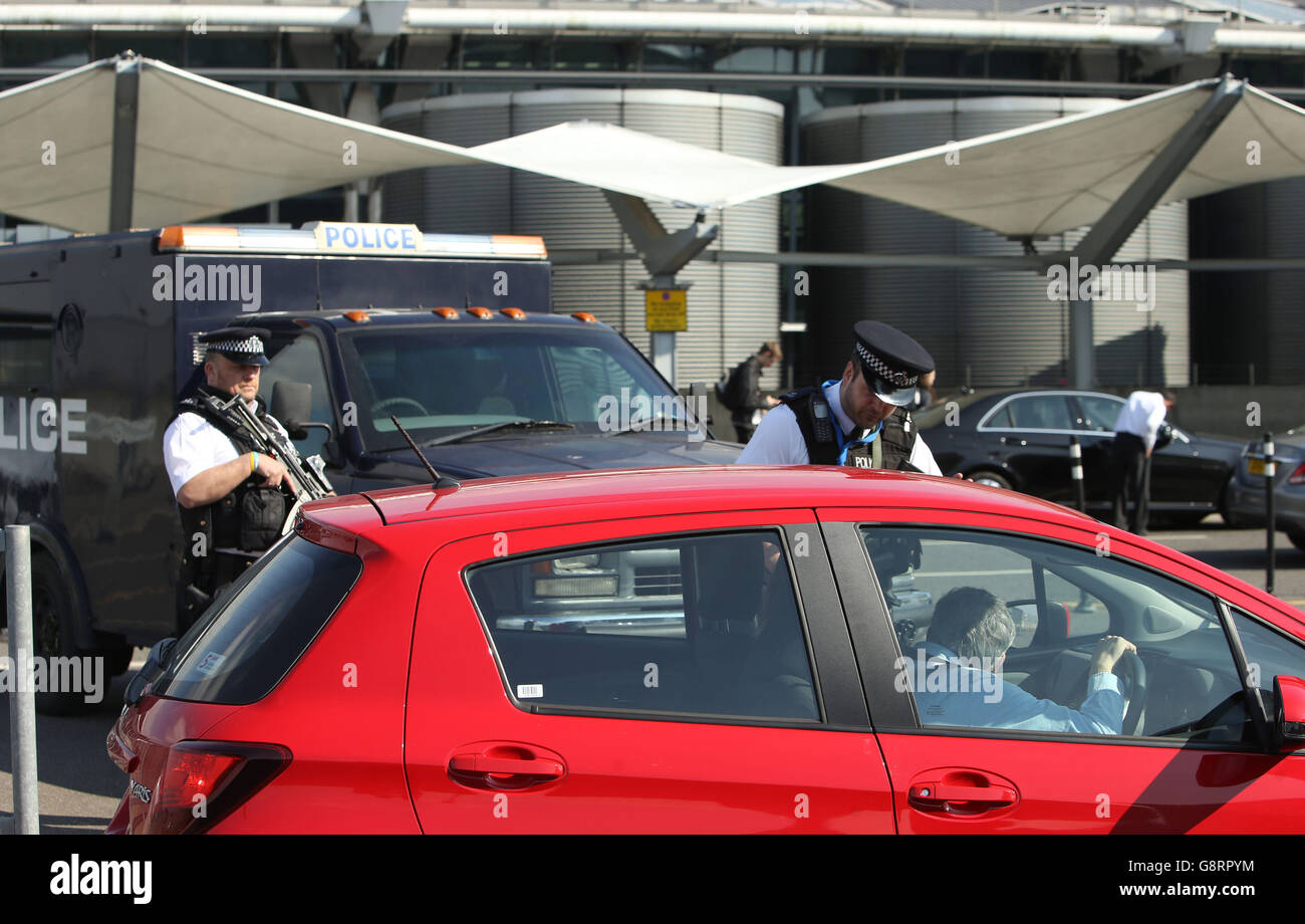 Bewaffnete Polizisten patrouillieren vor Terminal 5 am Londoner Flughafen Heathrow, da die Sicherheit an den Verkehrsknotenpunkten in Großbritannien nach Terroranschlägen in Brüssel verstärkt wurde. Stockfoto