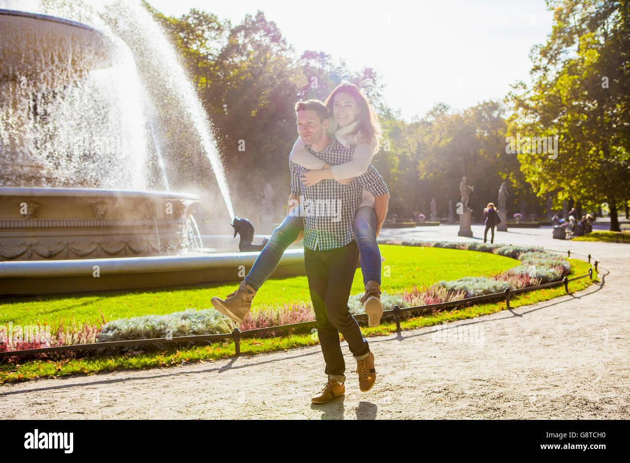 Mann mit seiner Freundin eine Huckepack im park Stockfoto