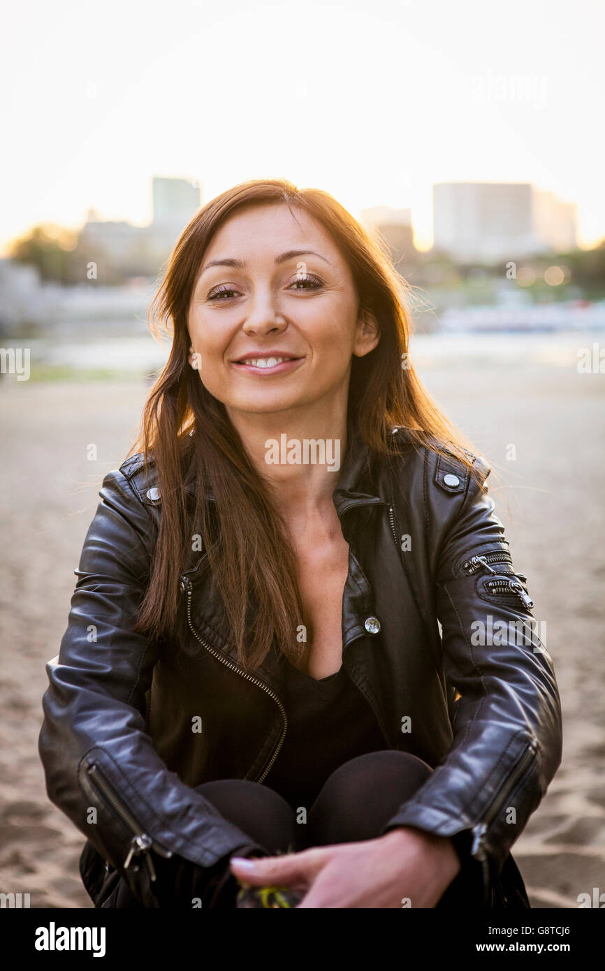 Mitte Erwachsene Frau mit braunen Haaren lächelnd am Strand Stockfoto