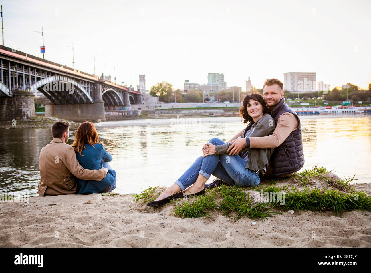 Gruppe von Touristen, die eine Pause am Rand des Wassers in der Stadt Stockfoto