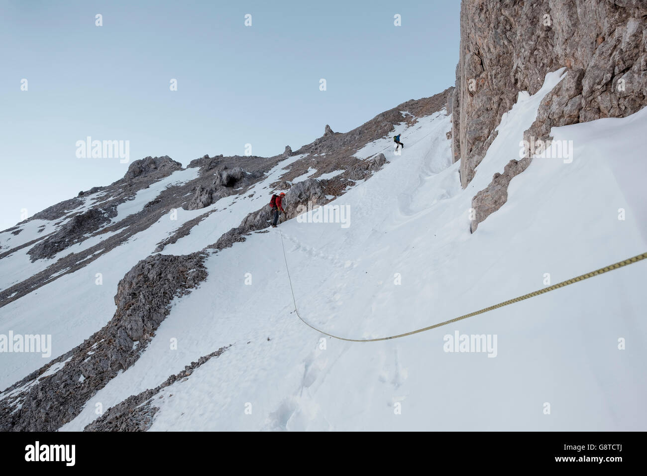 Zwei Bergsteiger hochschieben schneebedeckten Felsen im Gebirge Stockfoto