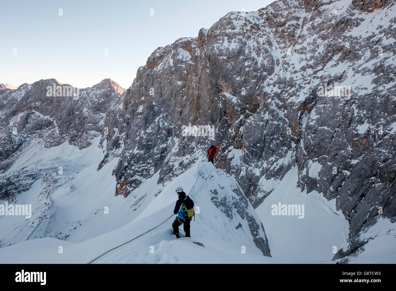 Zwei Bergsteiger hochschieben schneebedeckten Felsen im Gebirge Stockfoto