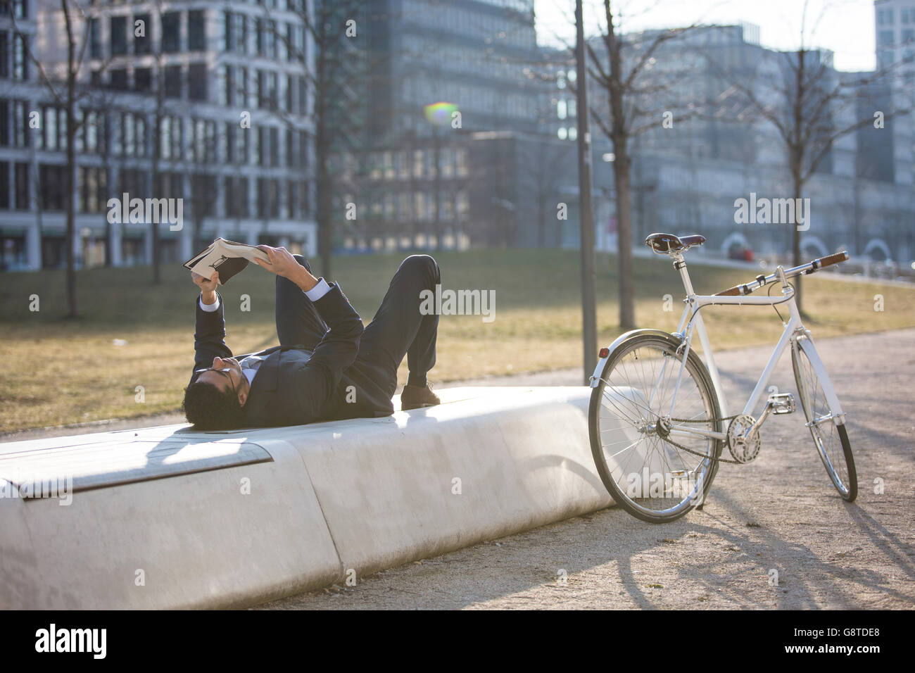 Geschäftsmann mit Fahrrad Lesebuch in Stadt Stockfoto