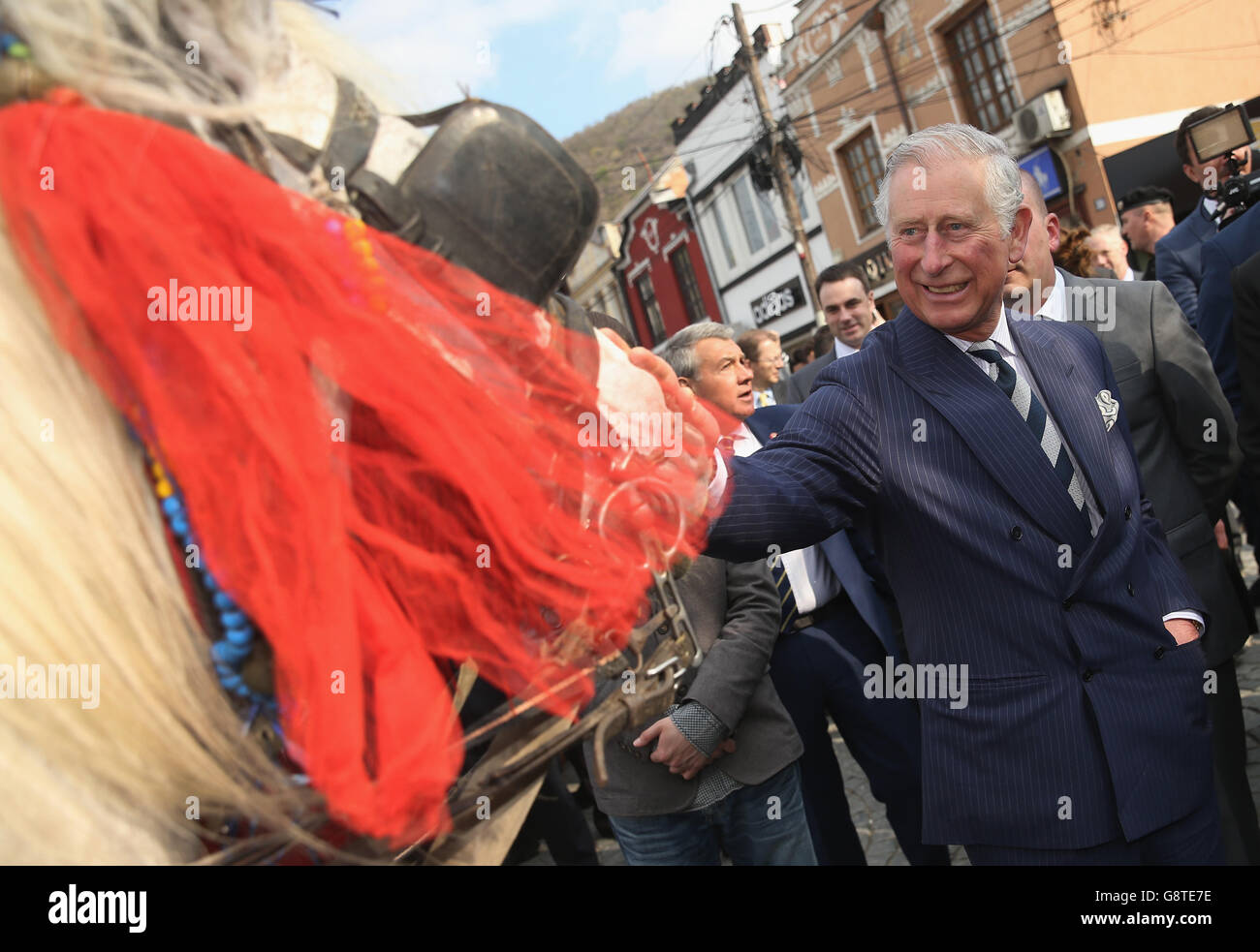 Der Prinz von Wales begrüßt ein Pferd, das an eine Kutsche gebunden ist, im alten Stadtzentrum von Prizren im Kosovo. Stockfoto