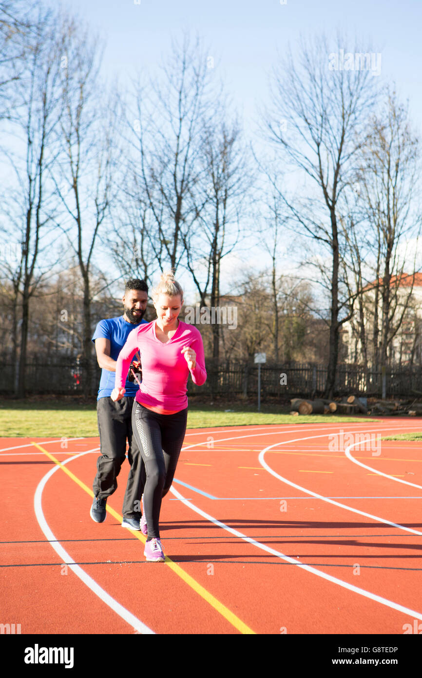 Junges Paar Ausübung am laufen verfolgt im Stadion Stockfoto