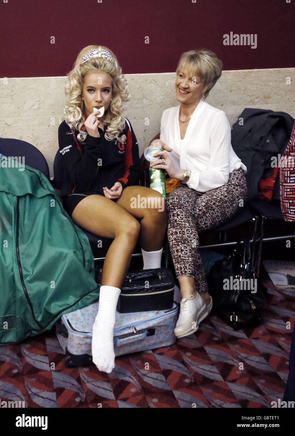 Ein Teilnehmer (links) entspannt sich während der Irish Dancing Championships in der Royal Concert Hall in Glasgow. Stockfoto