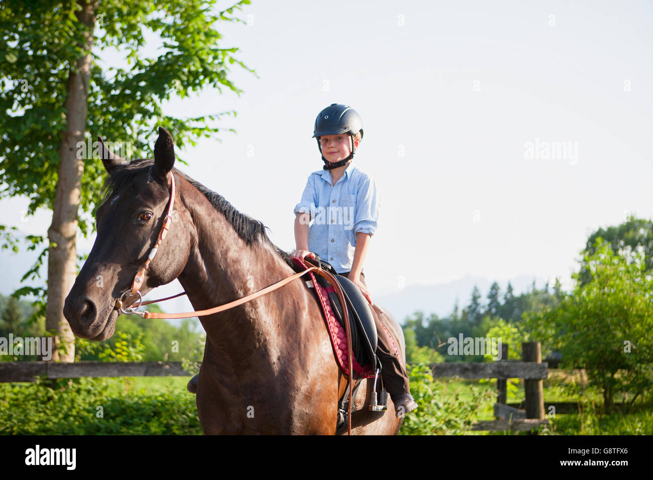 Junge auf Ranch lernt, wie man ein Pferd Reiten Stockfoto