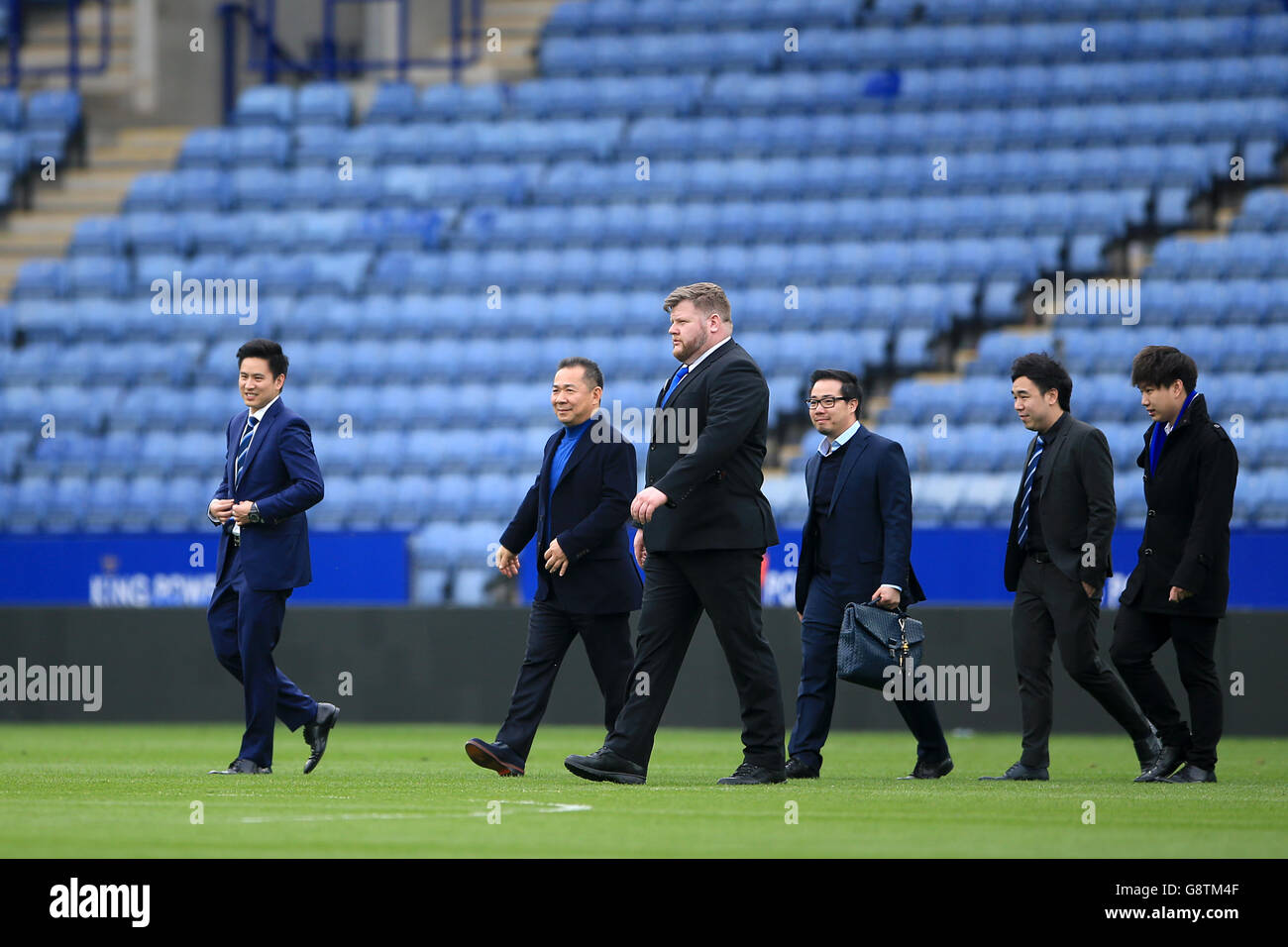 Leicester City Chairman Khun Vichai Srivaddhanaprabha (zweite links) und Vice Chairman Khun Aiyawatt 'Top' Srivaddhanaprabha (dritte rechts) gehen auf den Platz, um den Boden in einem Hubschrauber nach der letzten Pfeife in der Barclays Premier League Spiel im King Power Stadium, Leicester zu verlassen. Stockfoto