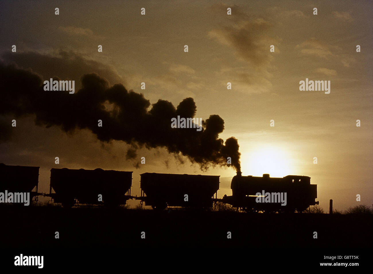 Sonnenaufgang im Netzwerk Backworth Zeche nördlich des Flusses Tyne findet eine strenge Hunslet 0-6-0ST schleppen einen geladenen Zug aus Stockfoto