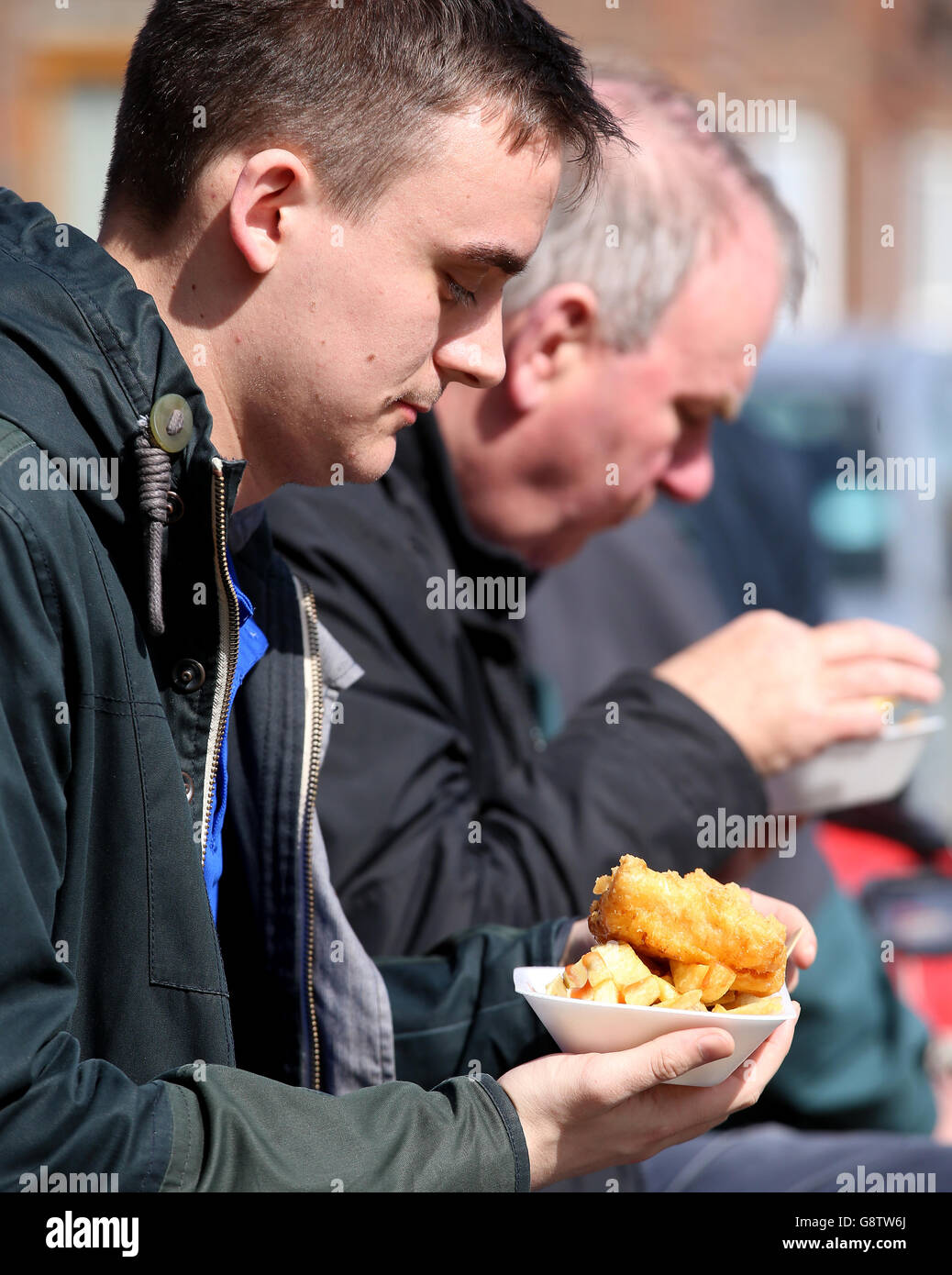 Fans essen vor uns Fisch und Chips im Sonnenschein Anstoß Stockfoto