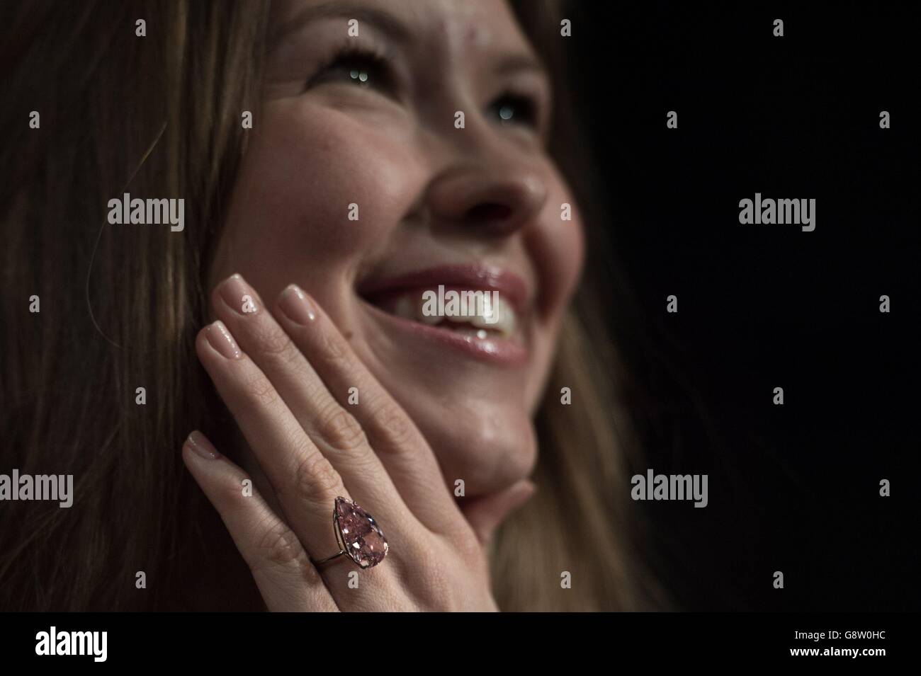 Ein Angestellter des Auktionshauses Sotheby's in London modelliert einen seltenen 'Fancy Vivid Pink' Diamanten namens 'Unique Pink', der im Mai in Genf zum Verkauf kommen wird, 15.38 Karat wiegt und voraussichtlich rund 28-38 Millionen Dollar einbringt. Stockfoto