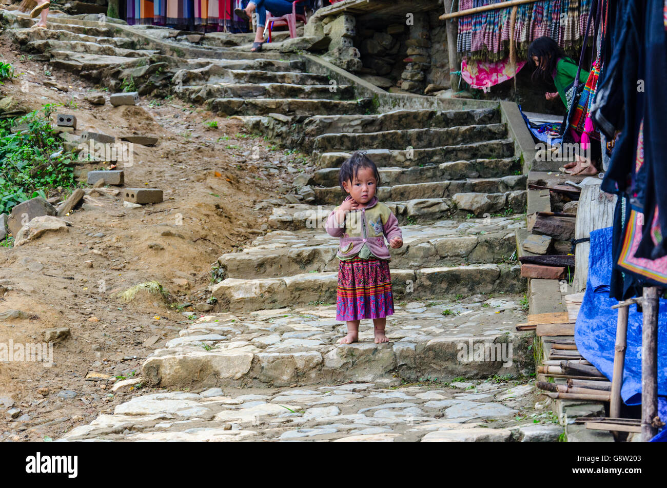 Kleine vietnamesische Kid vom Schwarzen Hmong Minderheit, in der traditionellen Kleidung in Cat Cat Dorf gekleidet, Sa Pa, North Vietnam Stockfoto