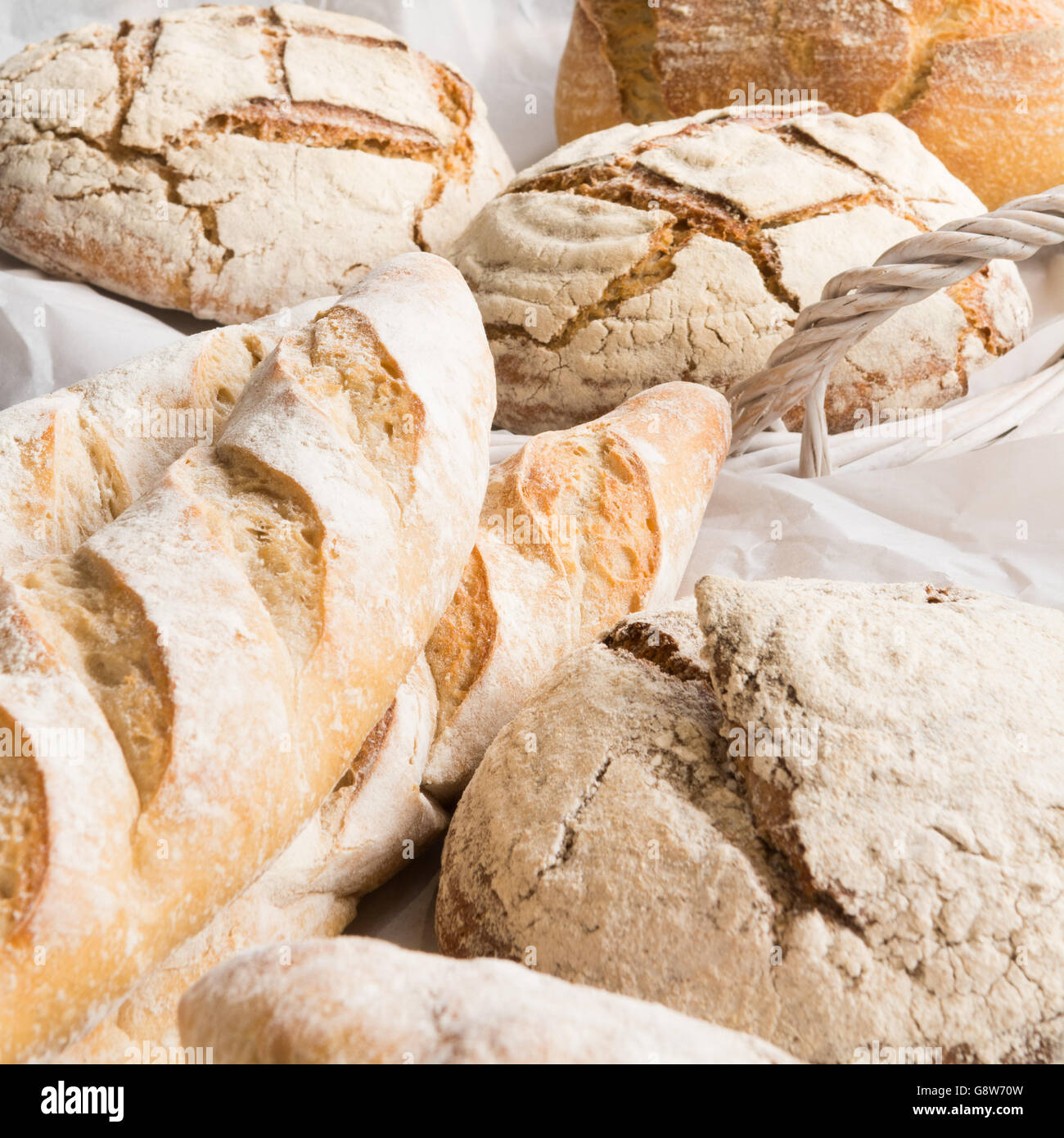 frisch gebackene Handwerker Brote in weißen geflochtenen Korb - Nahaufnahme Stockfoto