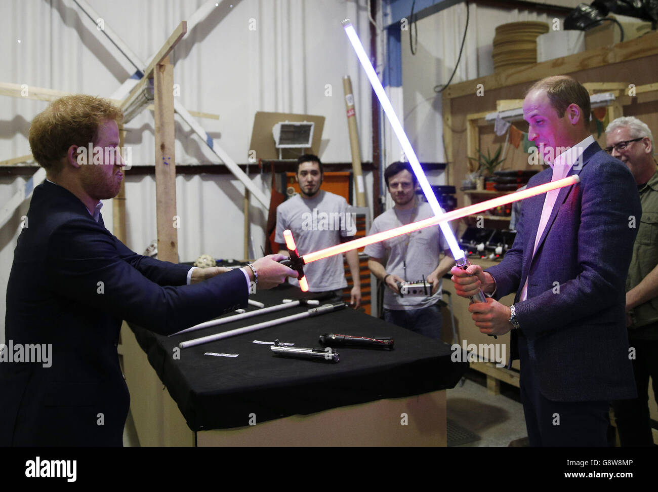 Prinz Harry (links) und der Herzog von Cambridge probieren Lichtschwerter während einer Tour durch die Star Wars-Sets in den Pinewood Studios in Buckinghamshire aus. Stockfoto