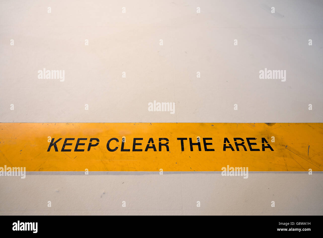 Halten Sie klare Warnzeichen im gelben Banner auf dem Boden, mit Textfreiraum Stockfoto