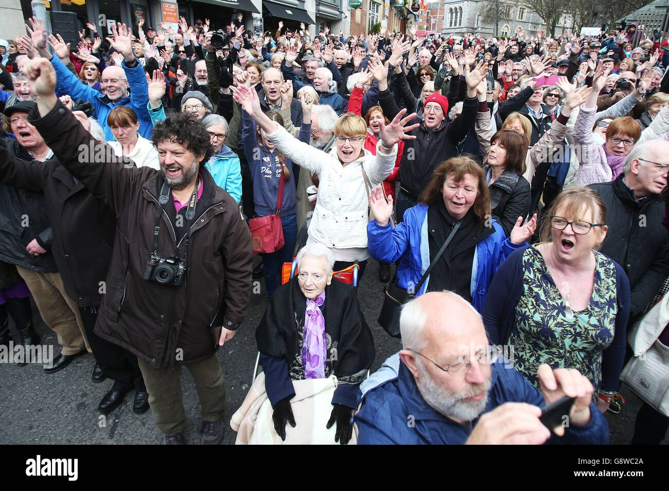 Hunderte von Menschen treffen sich mit Mitgliedern der Our Lady's Choral Society, begleitet vom Dublin Handelian Orchestra, während einer Aufführung von Händels Messias im Freien in der Fishamble Street, Dublin. Stockfoto