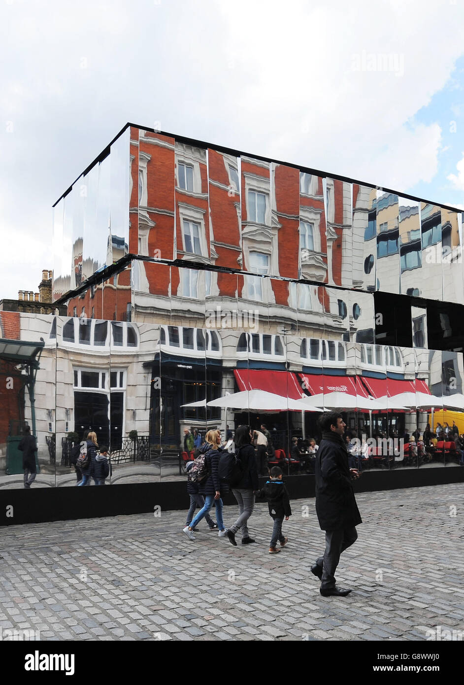 Die Menschen gehen an der neuen Installation Reflect London von Covent  Garden vorbei, die 32,000 Quadratmeter Spiegel um die östliche Fassade des  Market Building in Covent Garden im Zentrum von London wickelt