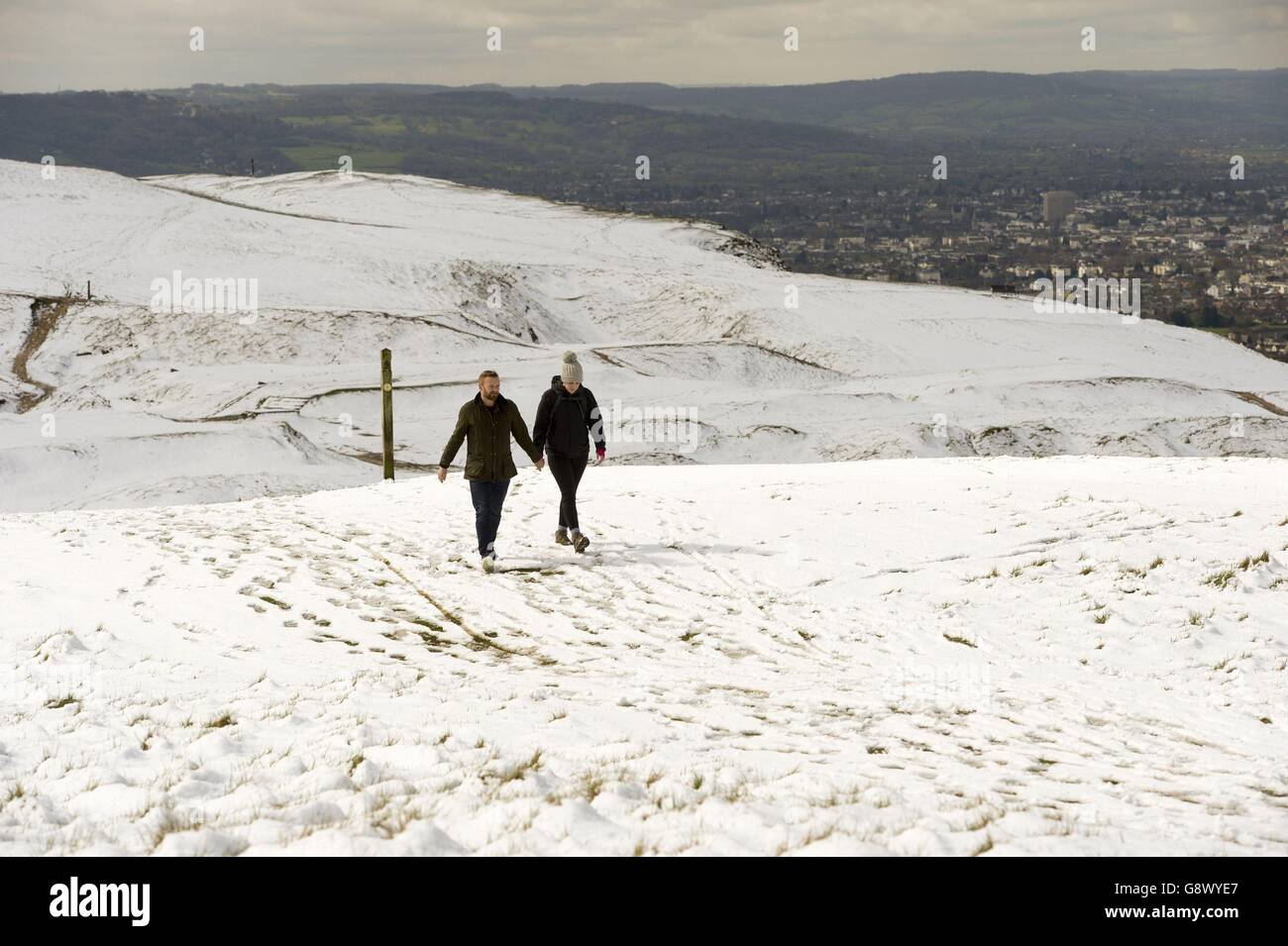 Menschen, die im Schnee auf Cleeve Hill, Cheltenham, als ein kalter Snap brachte ein plötzliches Ende des warmen Frühlings Wetter als Teile des Vereinigten Königreichs zu Schnee erwachte. Stockfoto