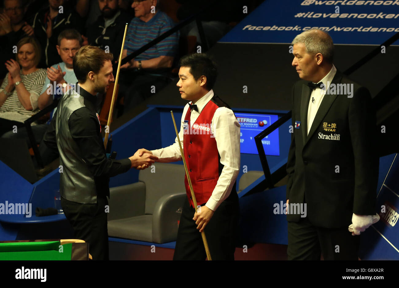 Judd Trump (links) und Ding Junhui geben sich nach ihrem Spiel am 10. Tag der Betfred Snooker World Championships im Crucible Theatre, Sheffield, die Hände. Stockfoto