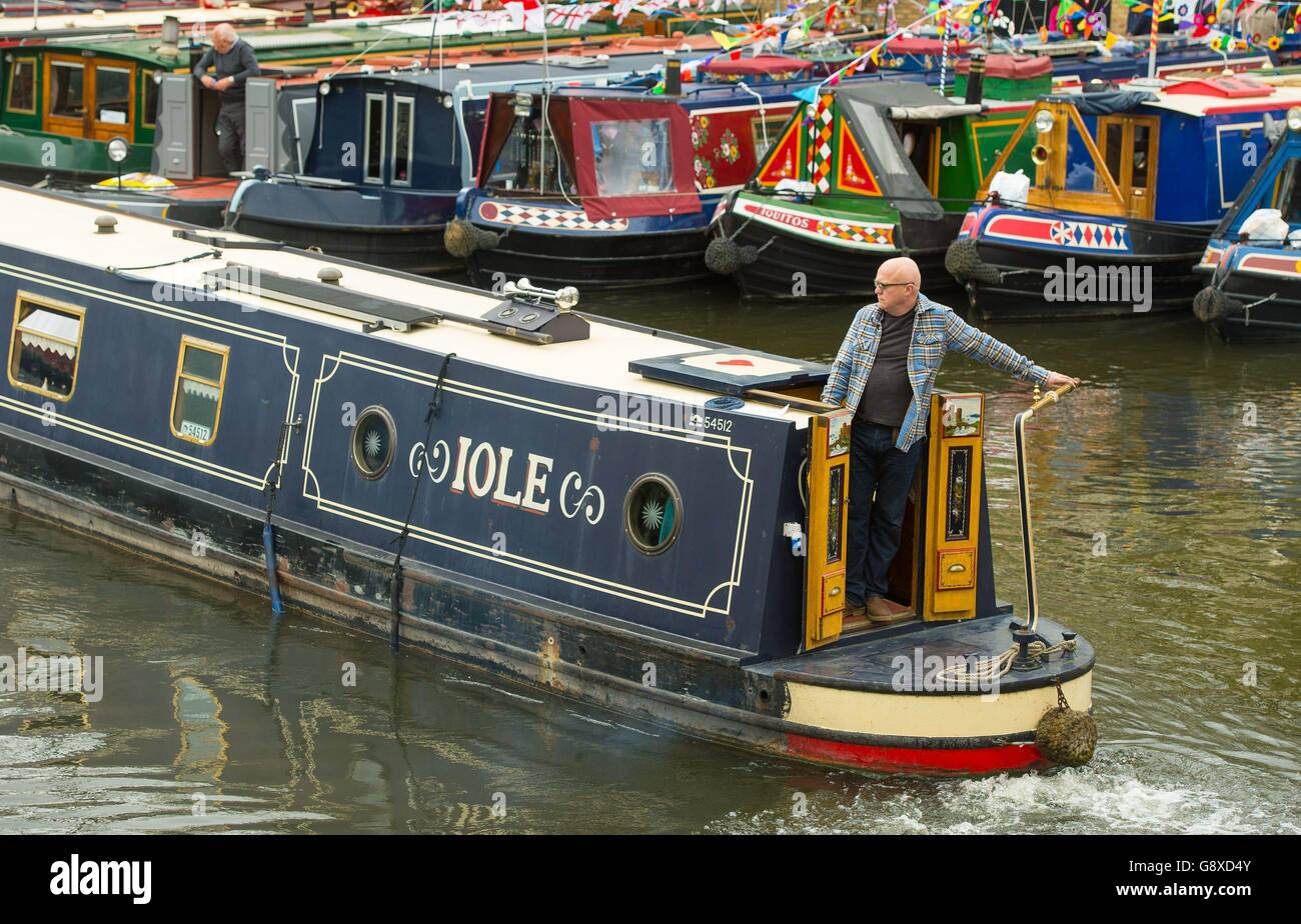 Ein Bootseigner nimmt an einem Bootsabfertigungswettbewerb Teil, der während des jährlichen Canalway Cavalcade Festivals der Inland Waterways Association in Little Venice, London, stattfindet, wo seit 1983 ein Treffen von geschmückten schmalen Booten stattfindet, die an Wettbewerben und Paraden teilnehmen. Stockfoto
