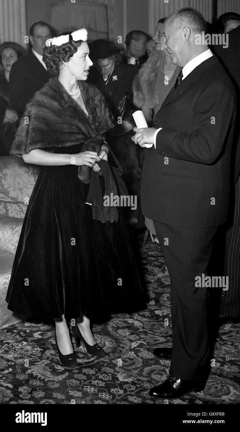 Prinzessin Margaret gratuliert dem französischen Designer Christian Dior lächelnd zu seiner Pariser Winterkollektion, die sie bei einer Präsentation zugunsten der British Red Cross Society im Blenheim Palace gesehen hatte. Stockfoto