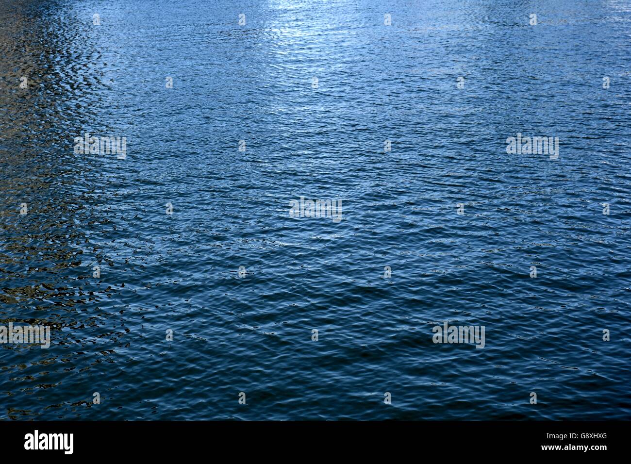 Wasserwellen über das ruhige Wasser der Bucht Stockfoto